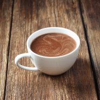 a cup of coffee sitting on top of a wooden table