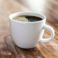 a close up of a coffee cup sitting on top of a wooden table