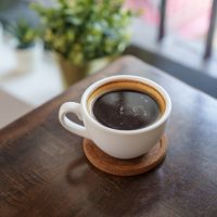 a cup of coffee sitting on top of a wooden table